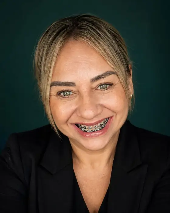 Kátia Fernandes, motorista executiva, sorrindo, de blazer preto